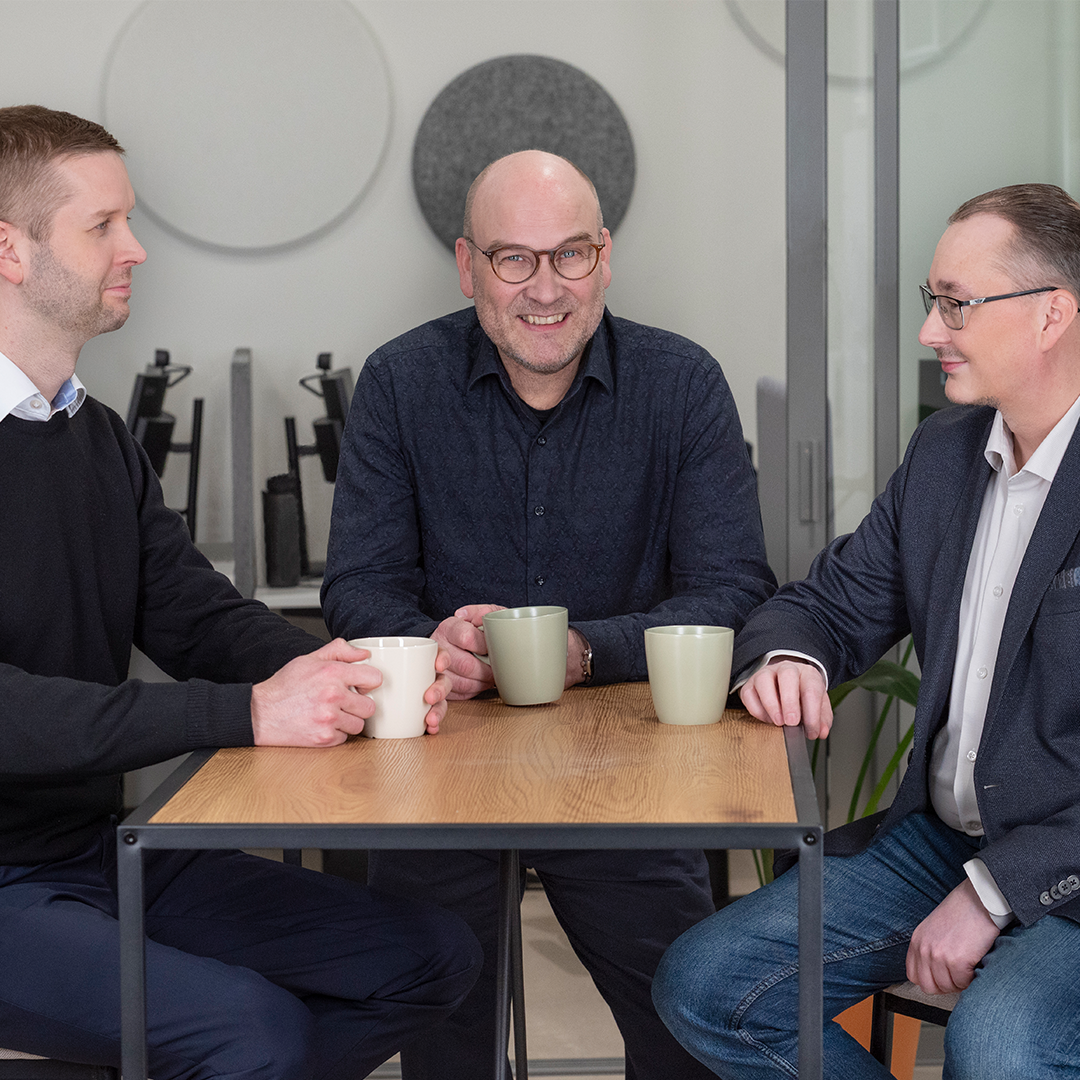 Veloralaiset istuvat pöydän äärellä